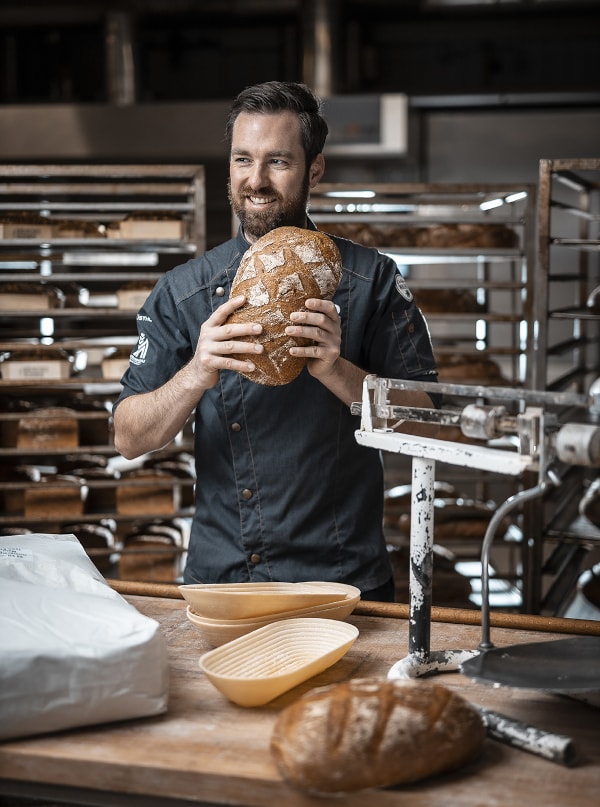 Bäcker hält Brot in der Hand