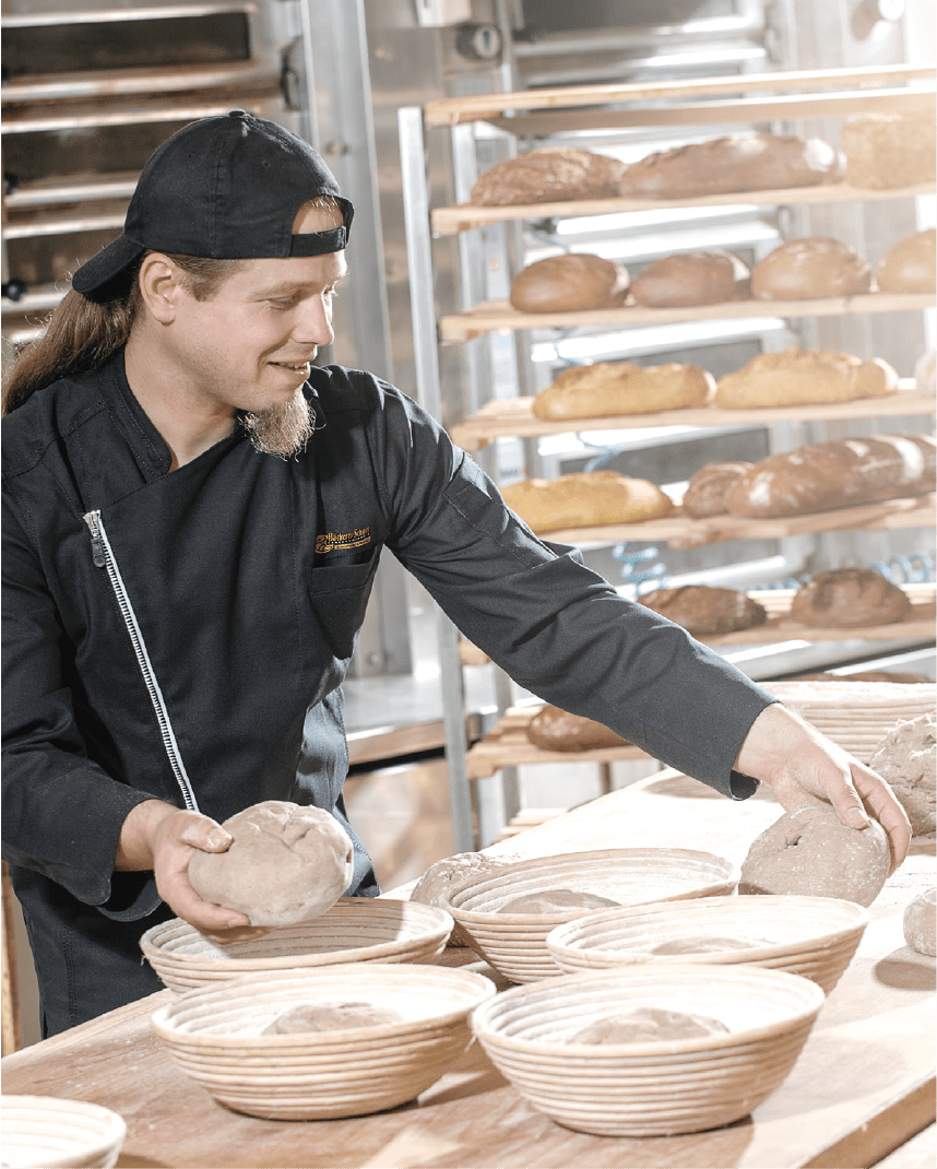 Bäcker schiebt Brote in den Ofen